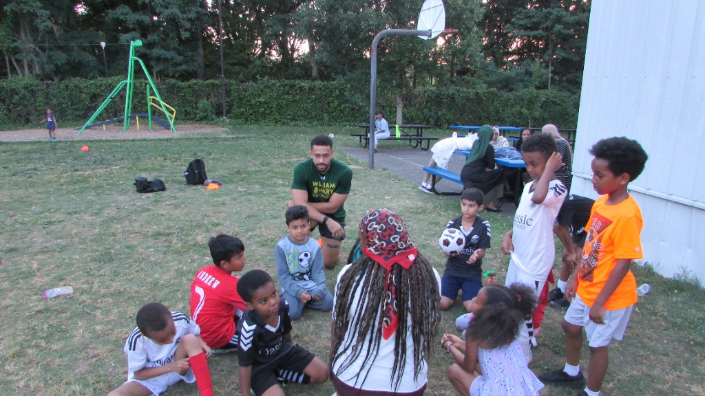 SOS team meeting with coach on the field